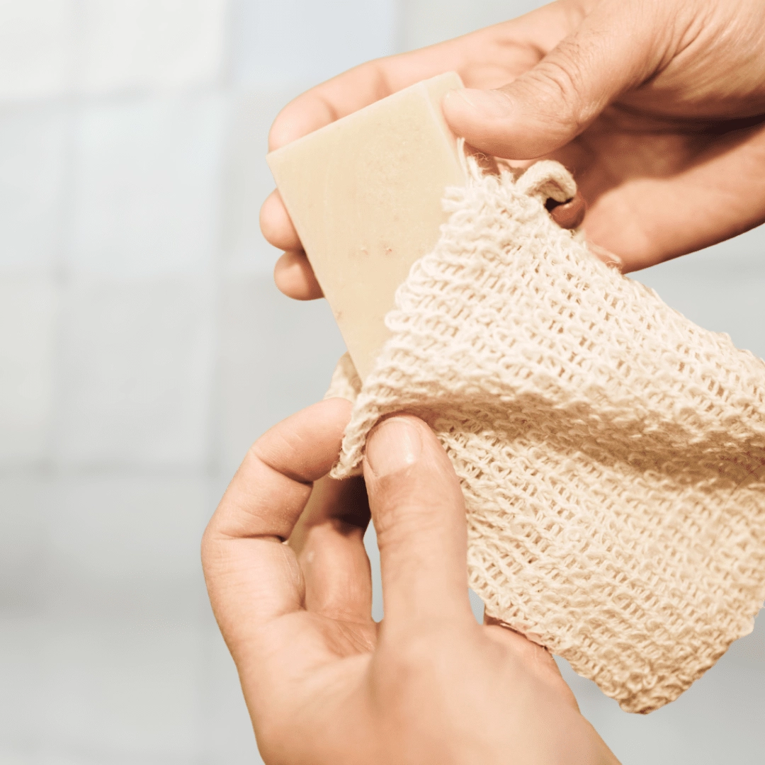 Hands holding a bar in a natural sisal soap saver bag